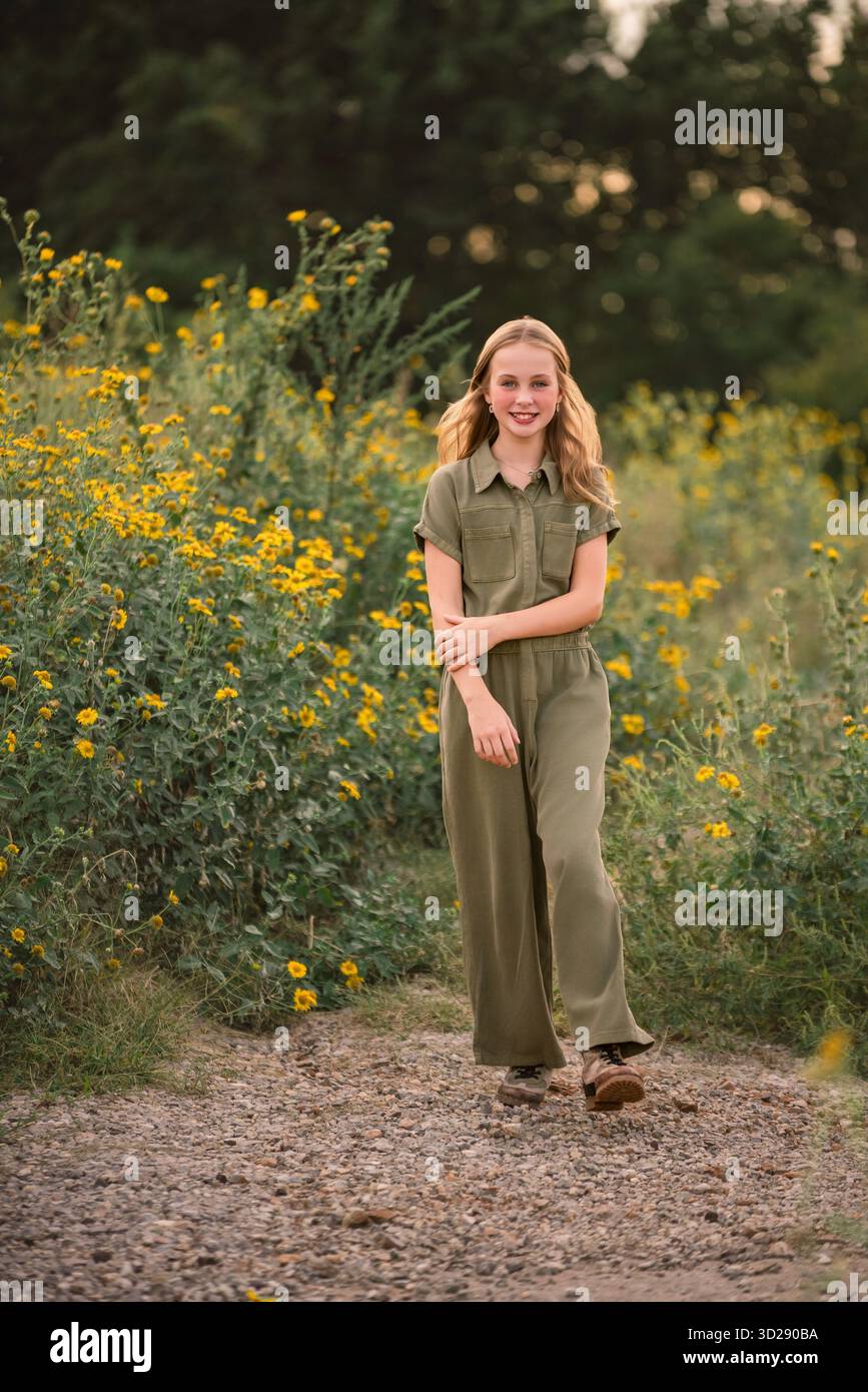 Vertikales Porträt eines Mädchens, das in einem Wildblumenfeld läuft Stockfoto