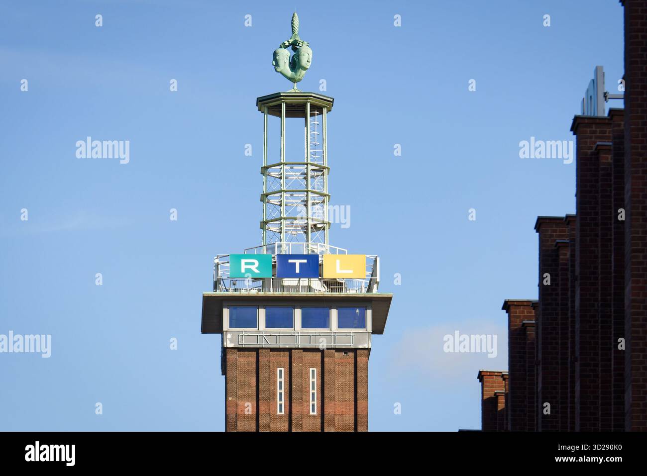 Köln, Deutschland Oktober 30 2025: Historischer Messeturm aus Backstein in Köln-Deutz, gekrönt von der ikonischen Hermes-Skulptur (1928) und dem modernen RTL-Fernsehen si Stockfoto