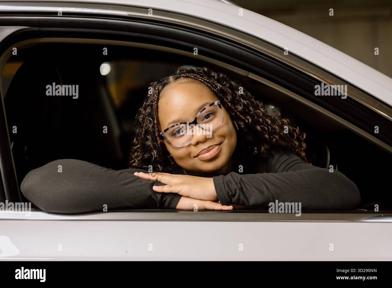 Lächelnde Frau in einem Autofenster Stockfoto