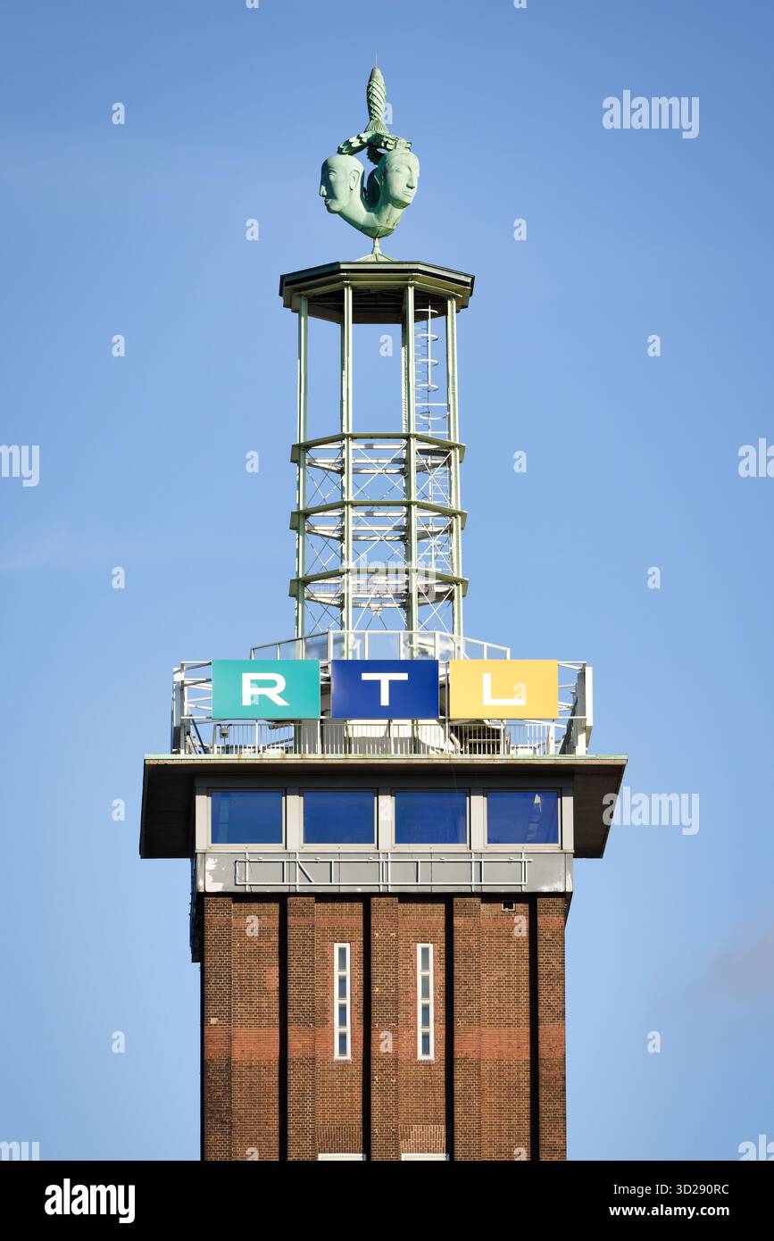 Köln, Deutschland Oktober 30 2025: Historischer Messeturm aus Backstein in Köln-Deutz, gekrönt von der ikonischen Hermes-Skulptur (1928) und dem modernen RTL-Fernsehen si Stockfoto