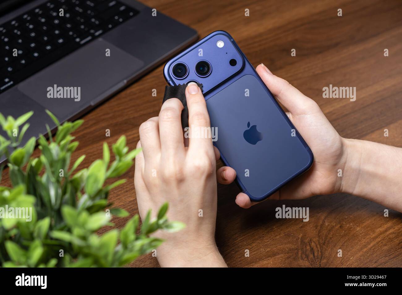 Posen, Polen – 16. Oktober 2025: IPhone 17 Pro, ein Benutzer, der das hintere Dreifachkamerasystem mit einem weichen Tuch für optimale Bildqualität reinigt Stockfoto
