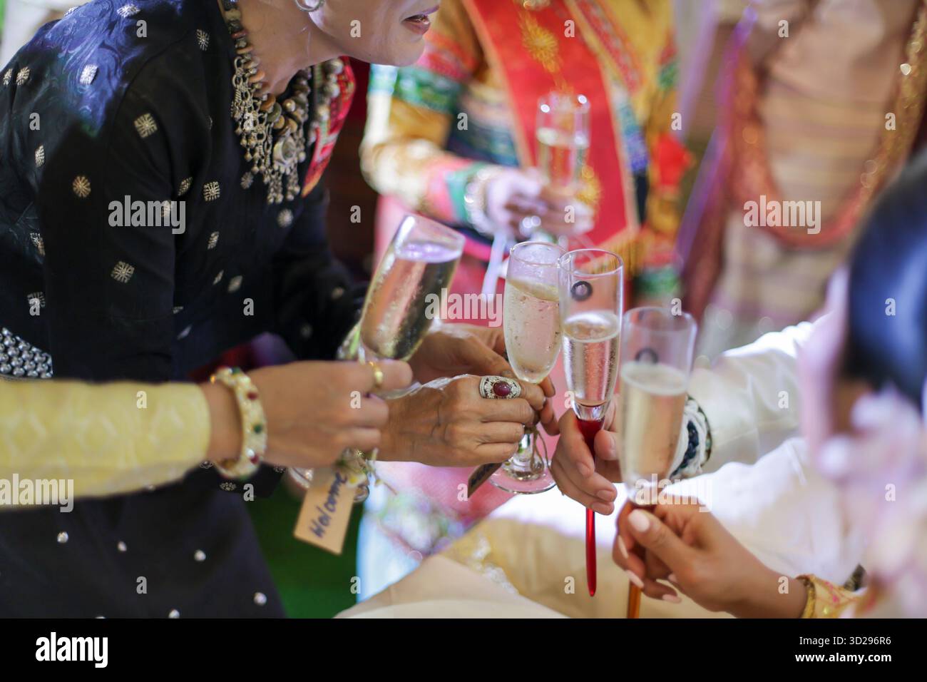 Selektive Focus Champagnergläser in der Hand, klirrende Gläser, Feiern, alkoholische Getränke, Begrüßungsgetränke bei einer Hochzeit Stockfoto