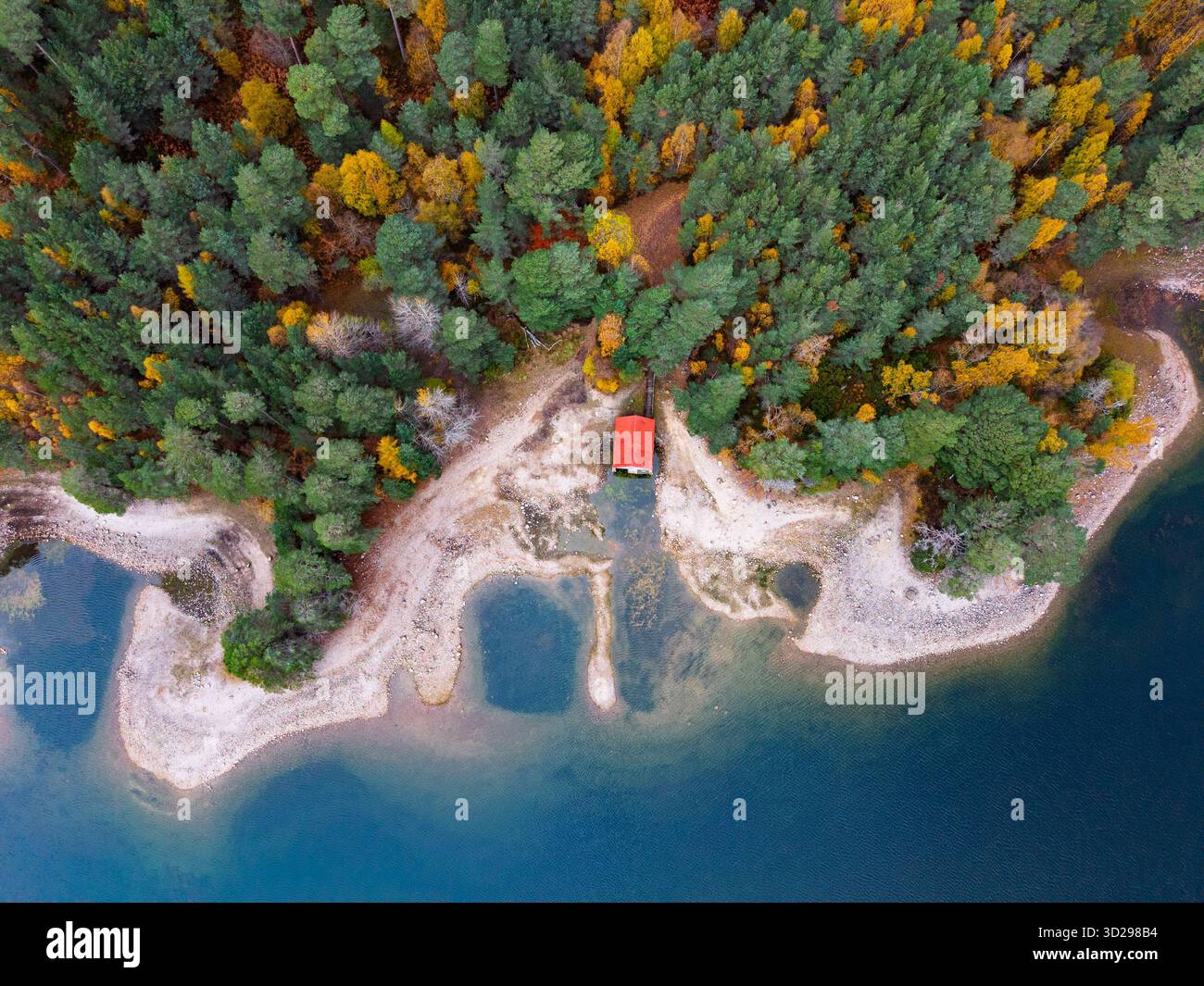 Luftaufnahme des roten Bootshauses hoch und trocken am Ufer des Loch VAA in der Nähe von Aviemore mit sehr niedrigen Wasserständen, Aviemore, Schottland, Großbritannien Stockfoto