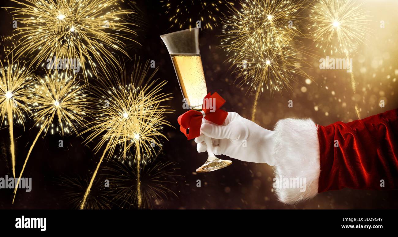 Silvester-Dinner-Konzept mit der Hand des Weihnachtsmanns, die ein Glas Sekt hält, mit einem Feuerwerk im Hintergrund. Stockfoto