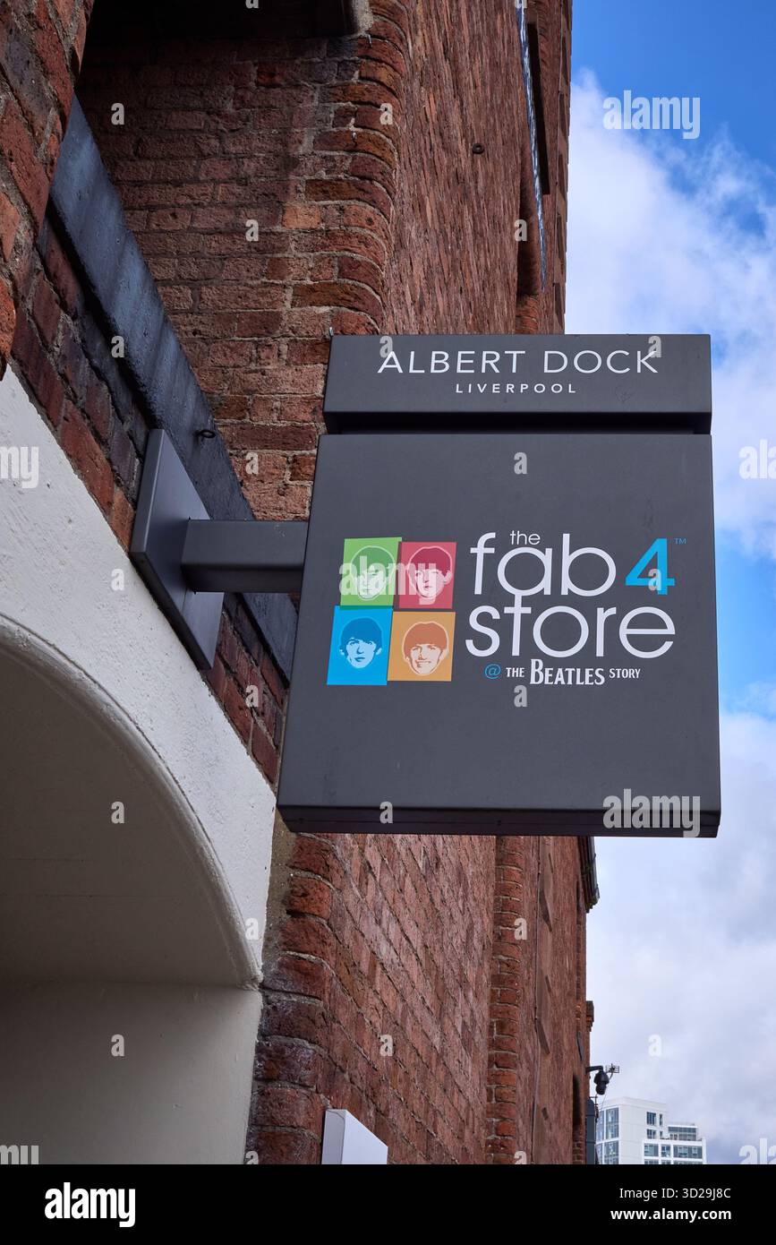 Fabelhaftes Schild mit vier Geschäften, das am historischen Backsteinlager am Albert Dock, dem berühmten Reiseziel der Beatles in Liverpool, unter dem Frühlingshimmel angebracht ist. Stockfoto