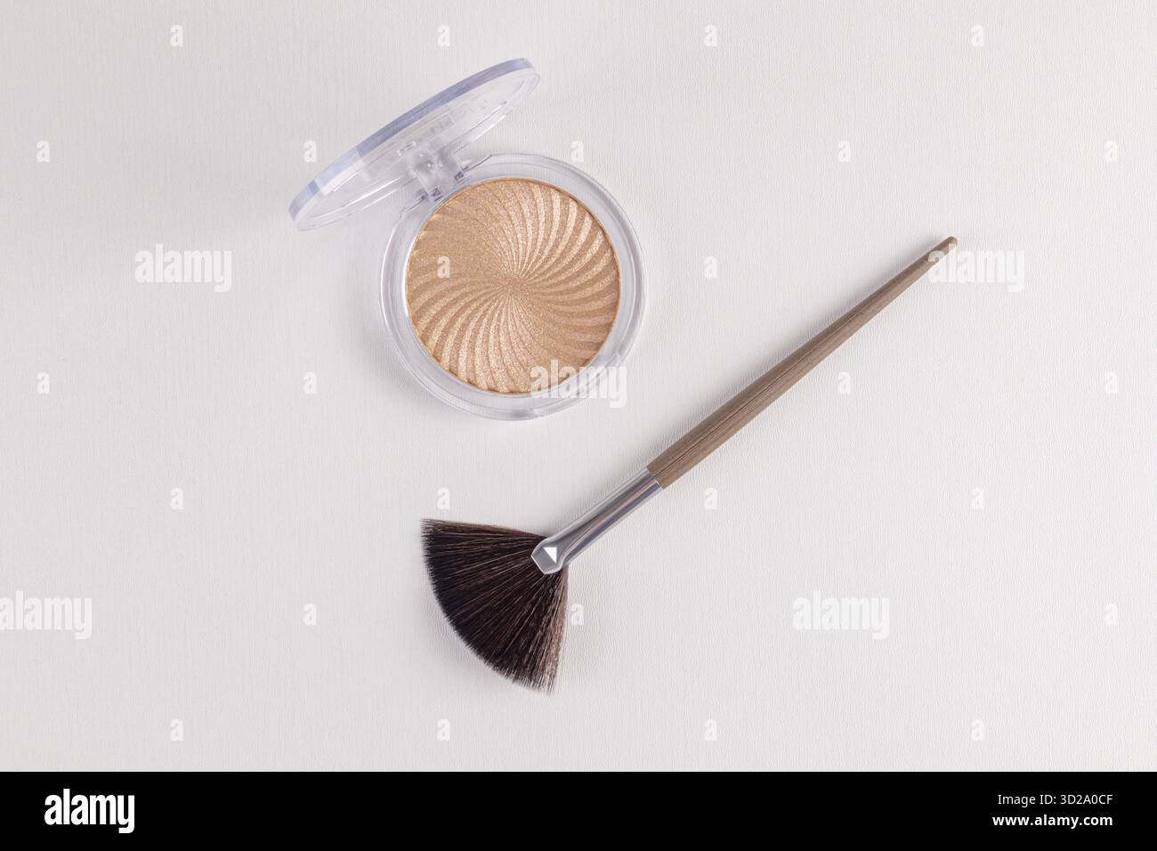 Runde Kosmetikverpackung mit schickem Highlighter und natürlichem Glanz. Fächer professionelle Make-up-Bürste. Die Draufsicht. Schönheit der hautdekorativen Kosmetik Stockfoto