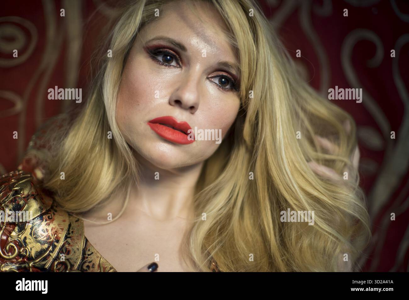 Schädel. Blondine in roten Rüstung Gold auf rot Jugendstil Schnörkel gekleidet Stockfoto