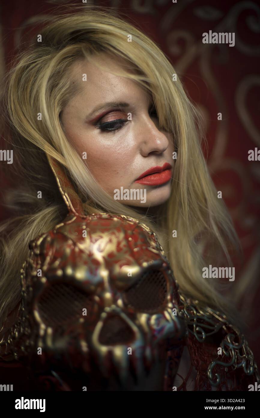 Schädel. Blondine in roten Rüstung Gold auf rot Jugendstil Schnörkel gekleidet Stockfoto
