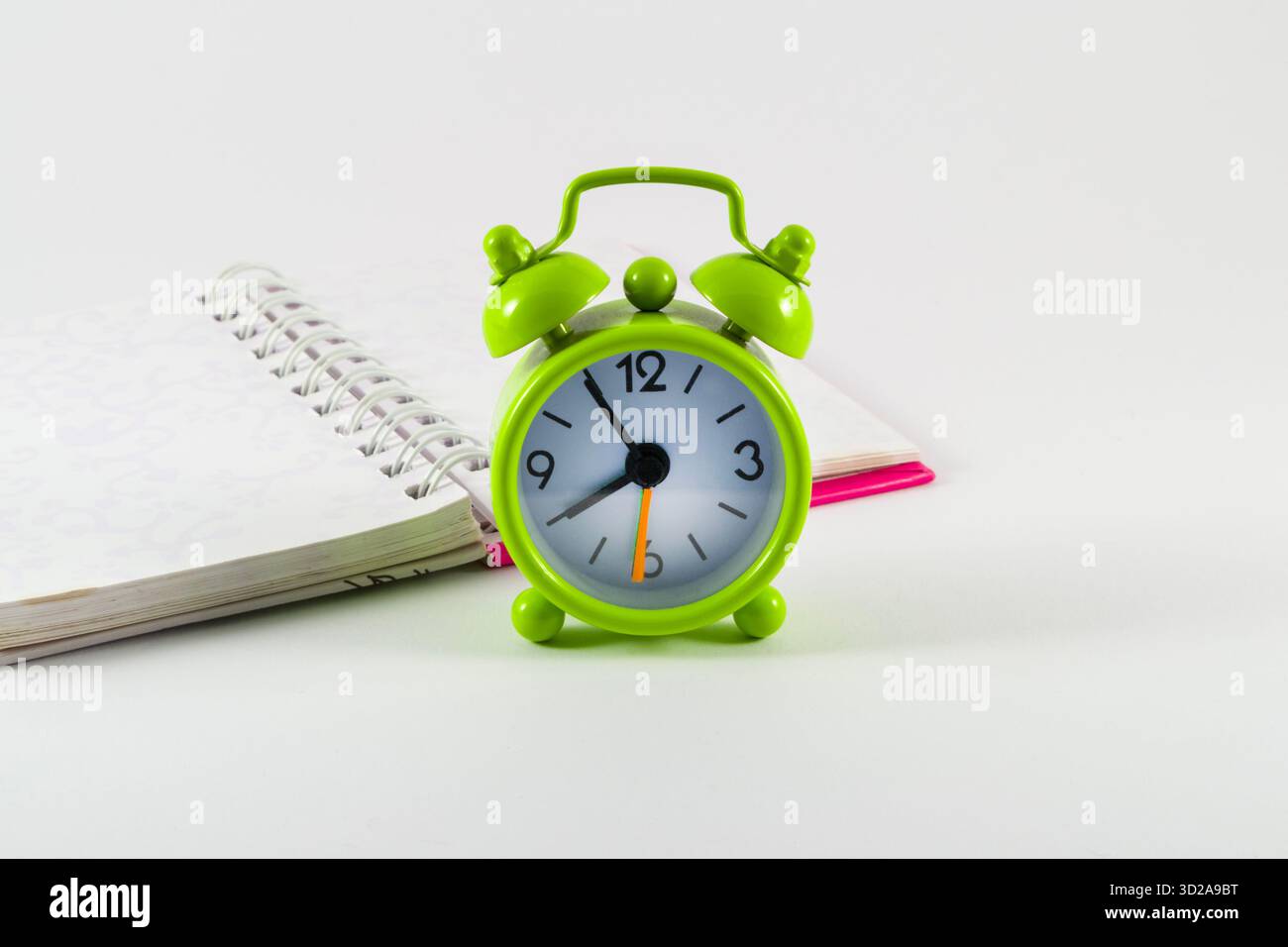 Grüner Wecker. Symbolisches Konzept von Zeitmanagement, Produktivität und achtsamer Planung in minimalistischer Zusammensetzung. Stockfoto