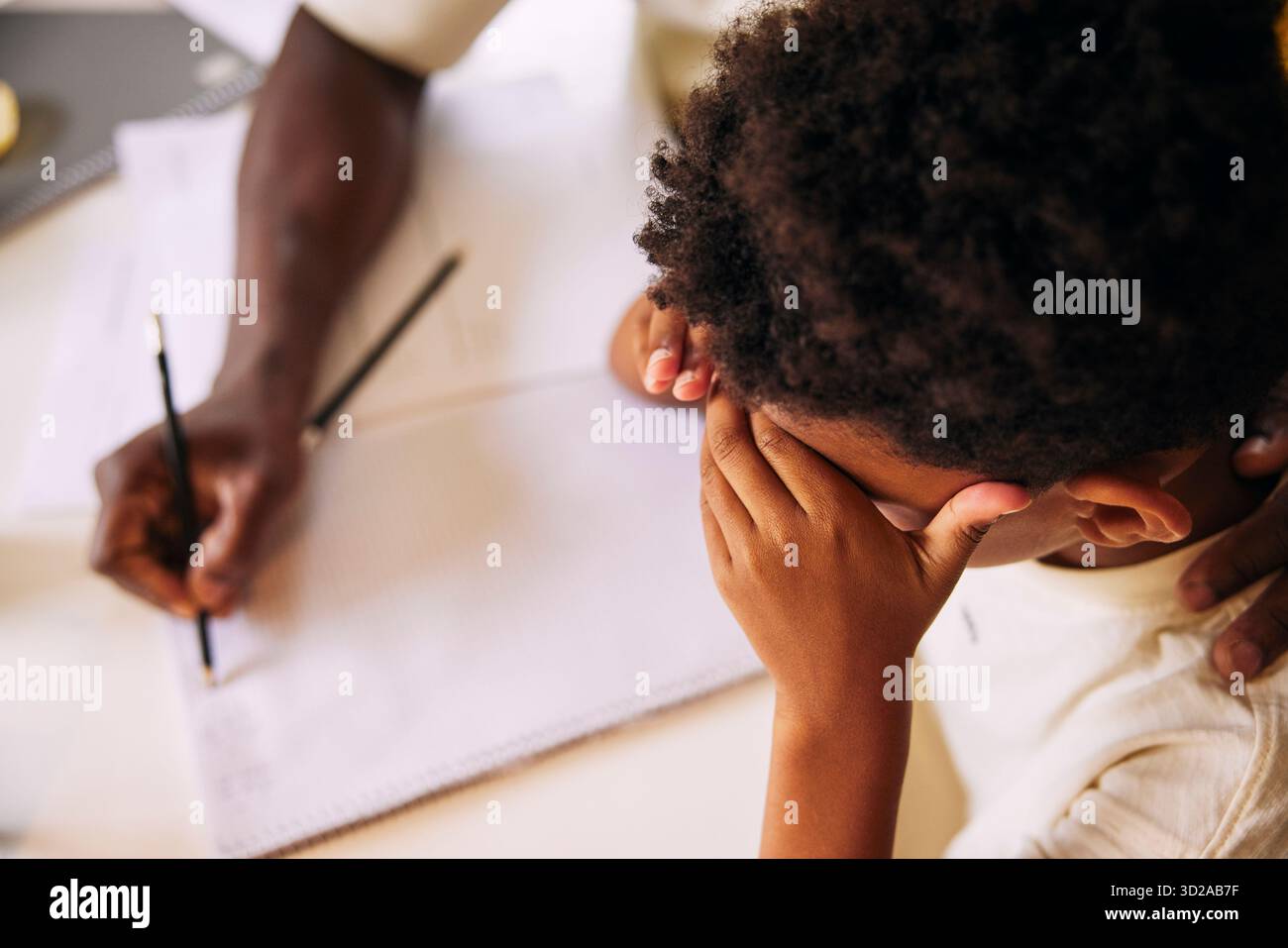 Hochwinkelansicht eines Jungen gestressten Jungen, der mit Vater studiert Stockfoto