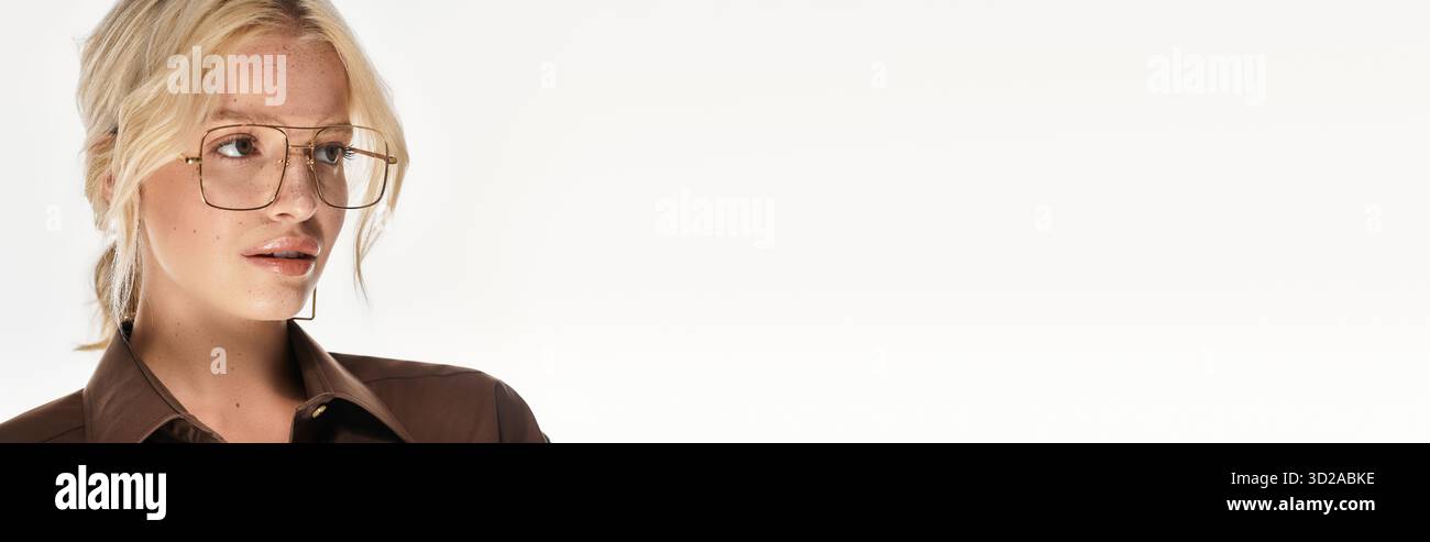 Eine schöne junge blonde Frau zeigt ihr modisches Winteroutfit in einem weißen Studio, Banner Stockfoto