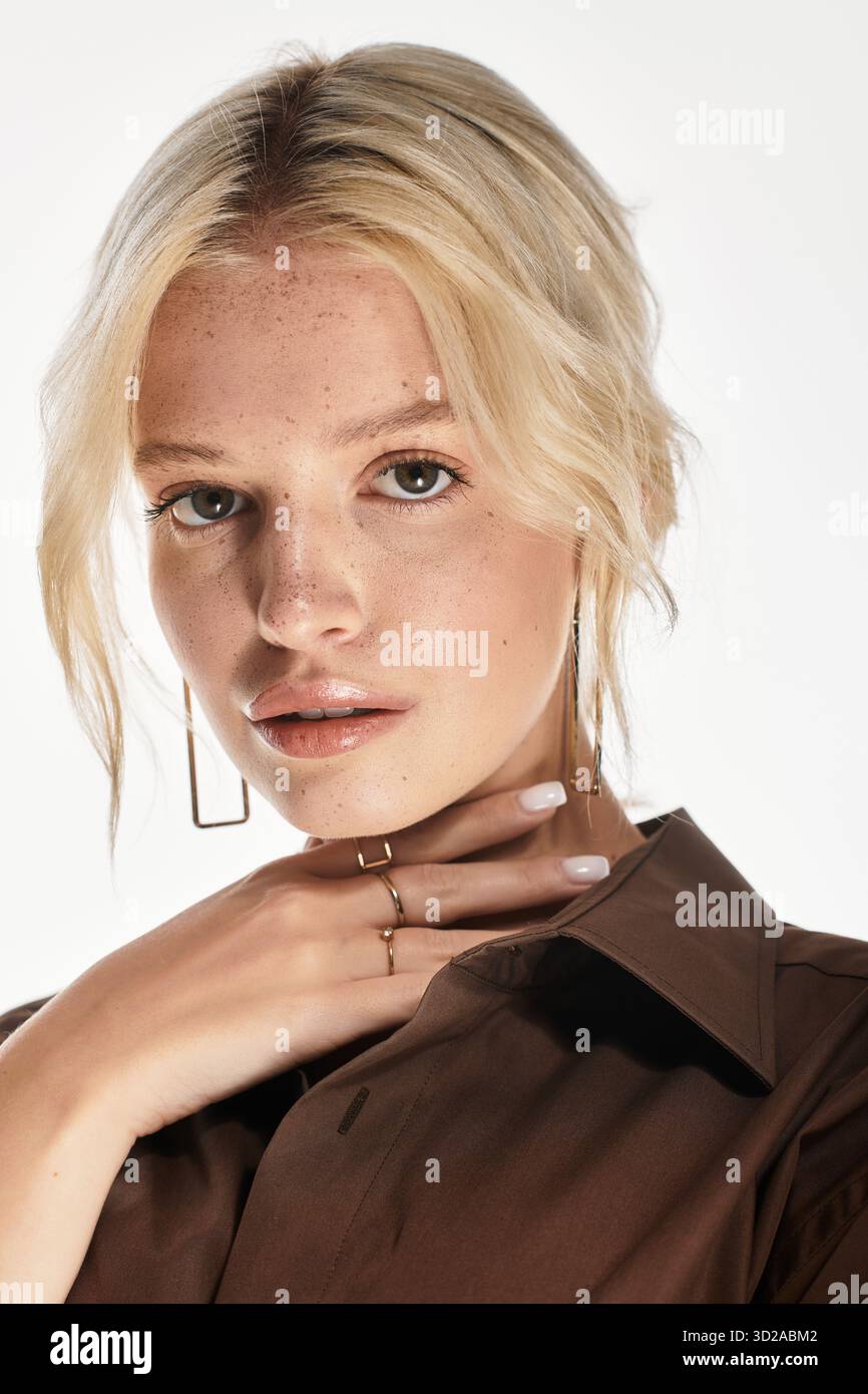 Stilvolle junge Frau posiert elegant und hebt ihr Winteroutfit in einem weißen Studio hervor. Stockfoto