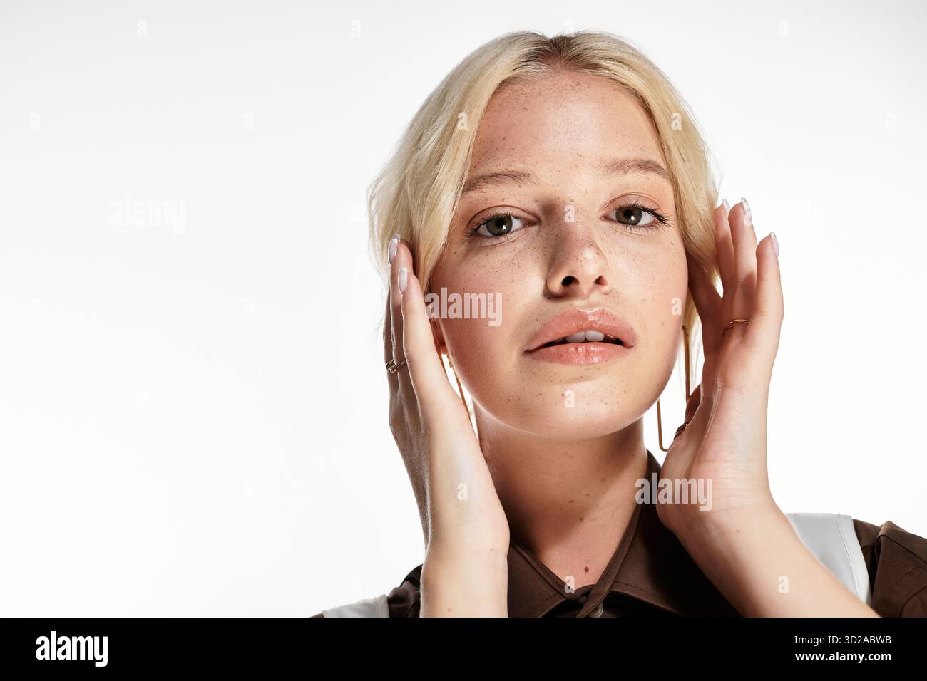 Stilvolle junge blonde Frau posiert in einem weißen Studio und präsentiert Wintermodetrends. Stockfoto
