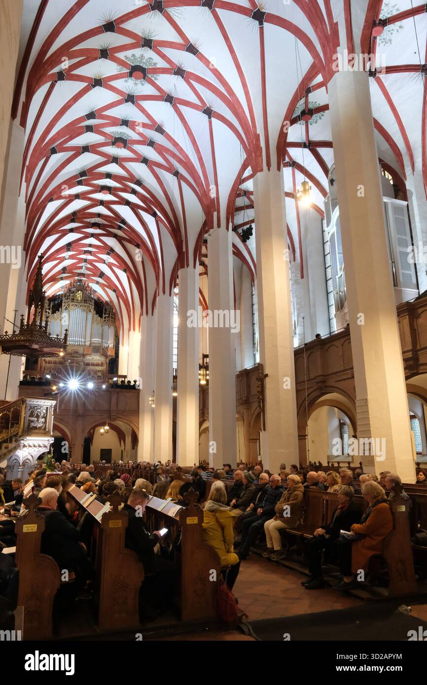 Leipzig, Deutschland. 31. Oktober 2025. Besucher der Thomaskirche sitzen in den Bänken für das Orgelkonzert. Ab 31.10. Bis zum 01.11.2025 findet dort ein großes musikalisches Projekt von Johannes lang, Organist an der Thomaskirche, statt. Innerhalb von 22 Stunden spielt lang in 14 Konzerten, die jeweils 90 Minuten dauern, die Gesamtwerke von Johann Sebastian Bach. Quelle: Sebastian Willnow/dpa/Alamy Live News Stockfoto