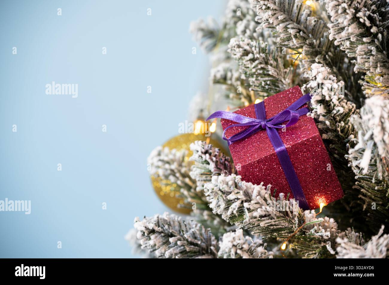 Weihnachtsbaumschmuck auf verschneite Kiefer auf blauem Hintergrund. Stockfoto
