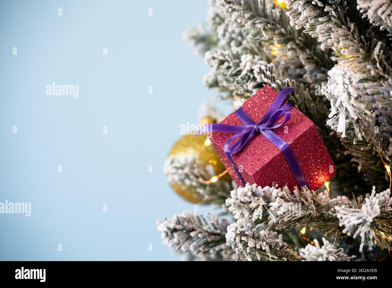 Weihnachtsbaumschmuck auf verschneite Kiefer auf blauem Hintergrund. Stockfoto