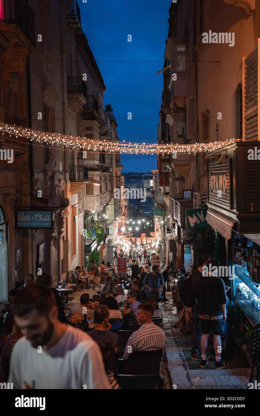 Valletta trat in der Abenddämmerung auf die Straße mit Lichtern, die zum Hafen führten Stockfoto