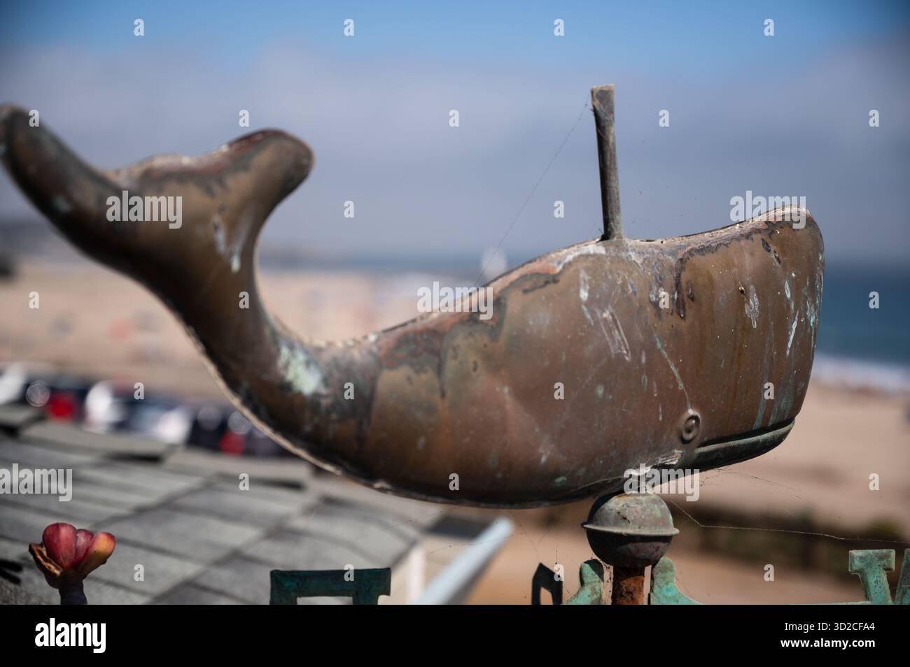 Verwitterte Wetterfahne mit Metallwal-Skulptur mit Blick auf den Okan Stockfoto