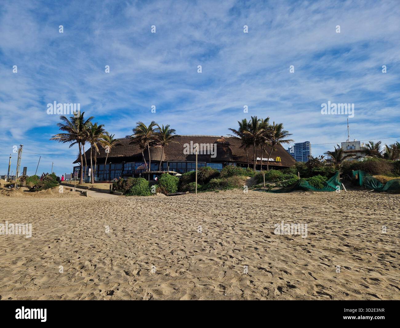 Einzigartige McDonald's mit Strohdach am Strand in Durban, Südafrika. - Smartphone-aufgenommenes Stockfoto