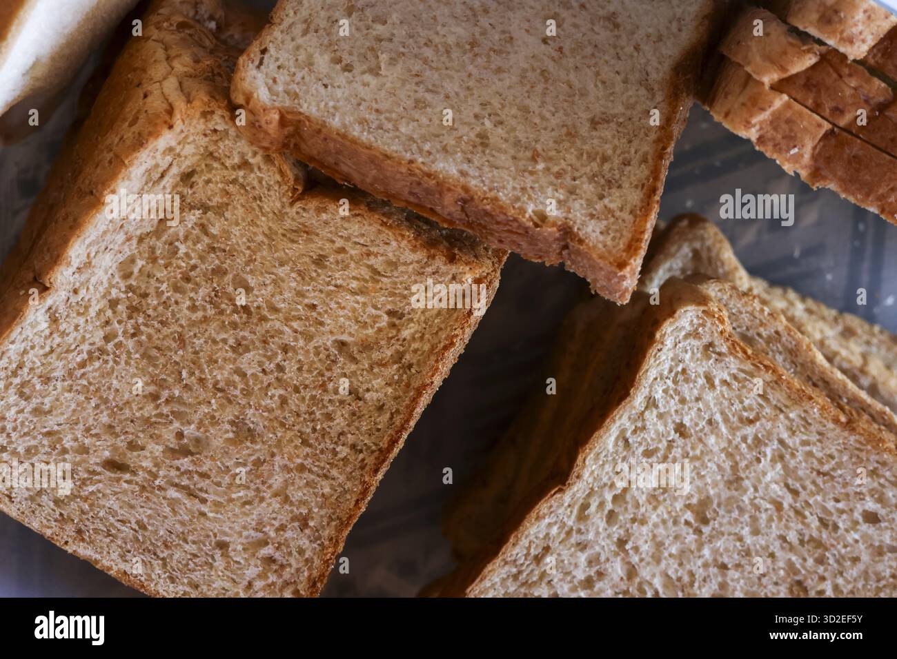 Gesunde Nahaufnahme von frisch geschnittenem braunem Brot. Hintergrund zeigt Stapel Vollkornbrot perfekt für gesunde Ernährung, Sandwich, Frühstück und Nuss Stockfoto