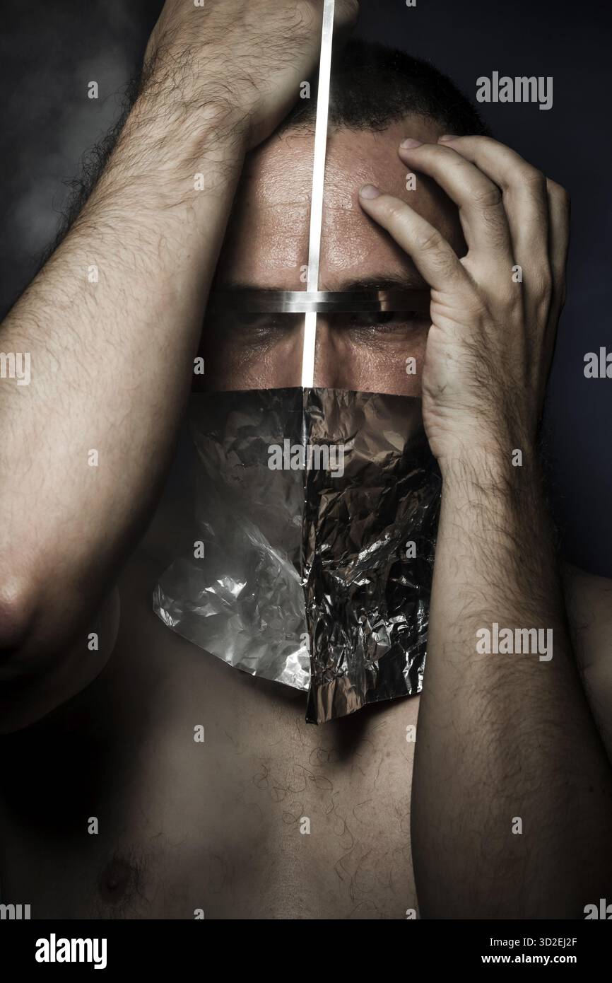Geheimnis, Konzept von Angst und Schrecken, nackter Mann mit Hardware im Gesicht Stockfoto