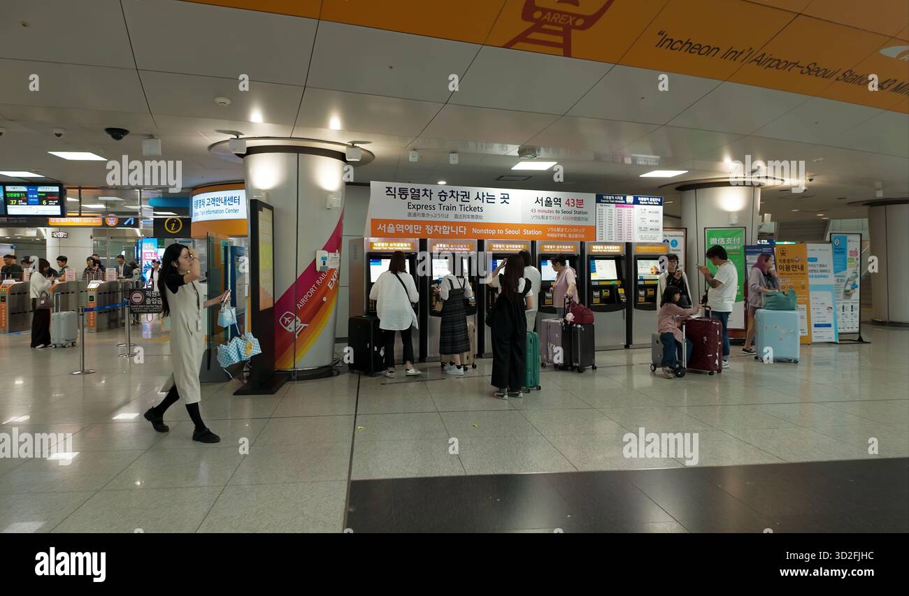 SEOUL, SÜDKOREA - 11. OKTOBER 2025 - Reisende, die am internationalen Flughafen Incheon Express-Zugfahrkarten an Automaten kaufen Stockfoto