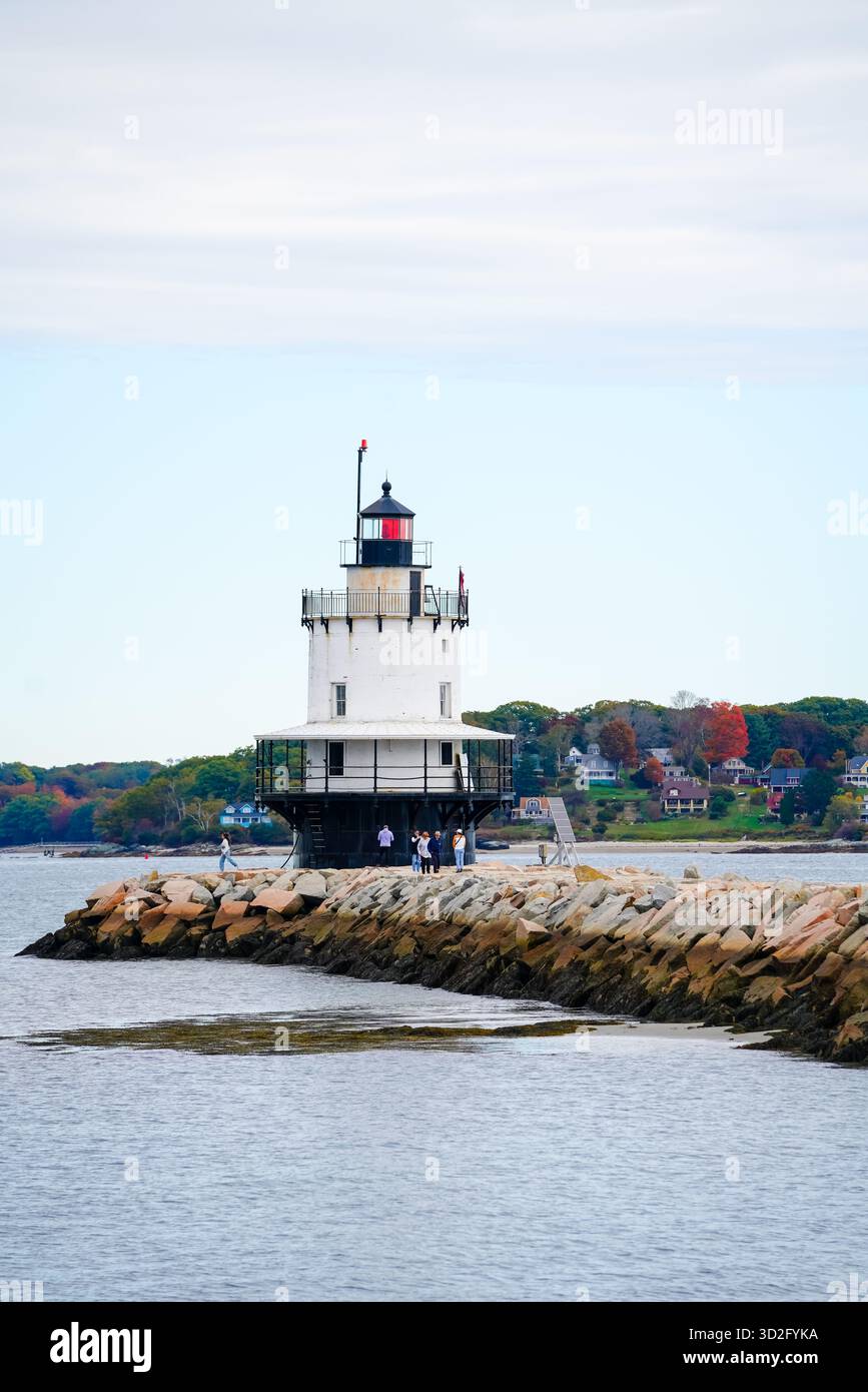 Besucher spazieren an einem Herbstnachmittag entlang der felsigen Mole zum Spring Point Ledge Lighthouse. Stockfoto