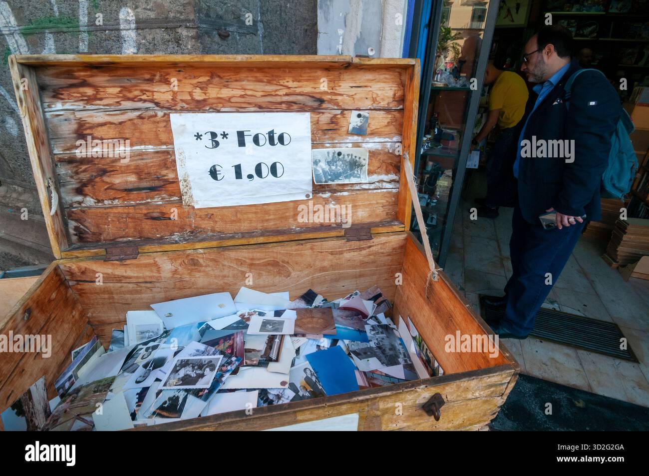 Eine Holzkiste mit Vintage-Fotos zum Verkauf vor einem Geschäft auf der Piazza Dante, Neapel. Stockfoto