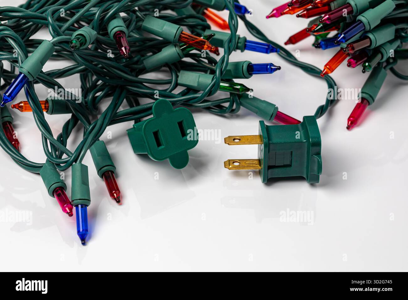 Mini Weihnachtsbeleuchtung Steckdose isoliert auf weißem Hintergrund. Sicherheit, Inspektion und Beleuchtungskonzept für die Weihnachtsdekoration. Stockfoto