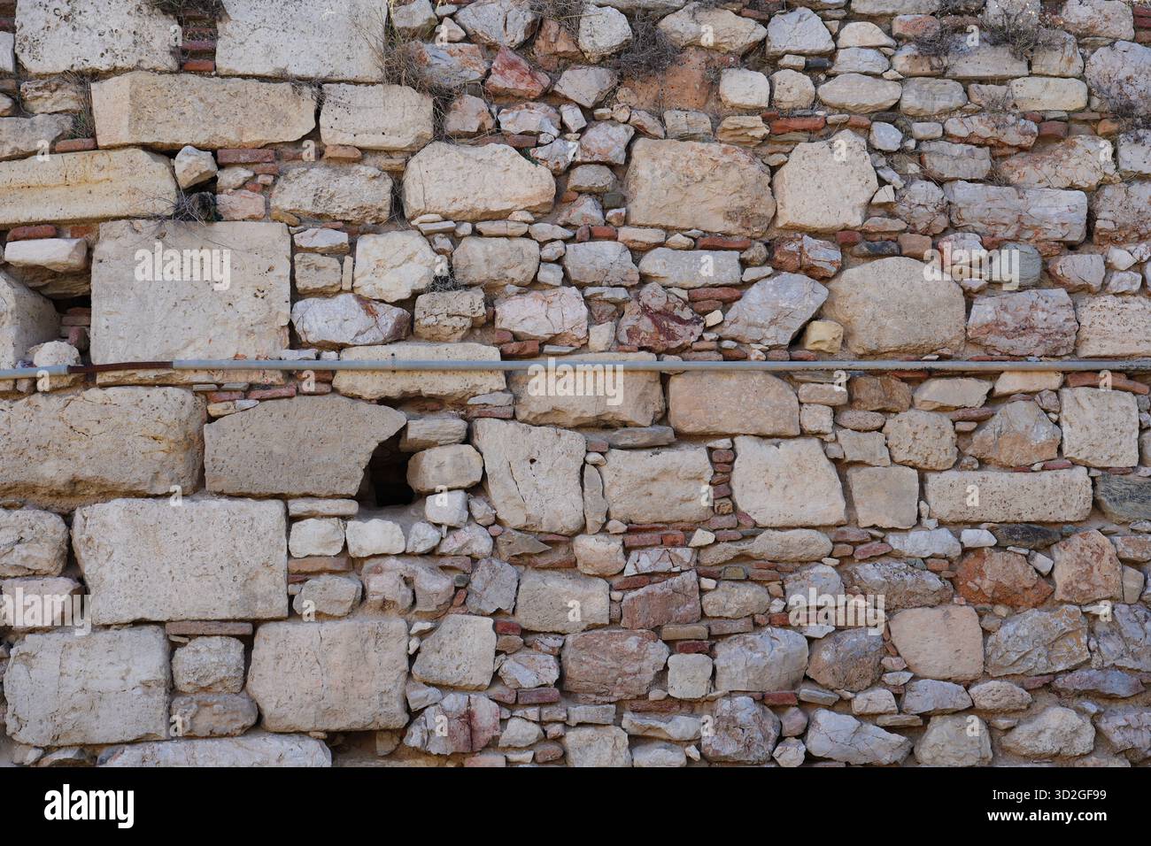 Nahaufnahme einer alten Steinmauer in Athen, Griechenland, mit rauer Textur, gemischtem Mauerwerk und historischen Baudetails. Stockfoto