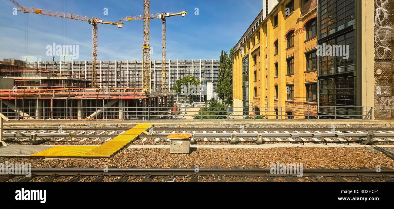Berlin, Deutschland - 17. Juni 2025: Baustelle mit Kränen und modernen Gebäuden an Bahngleise. - Smartphone-aufgenommenes Stockfoto
