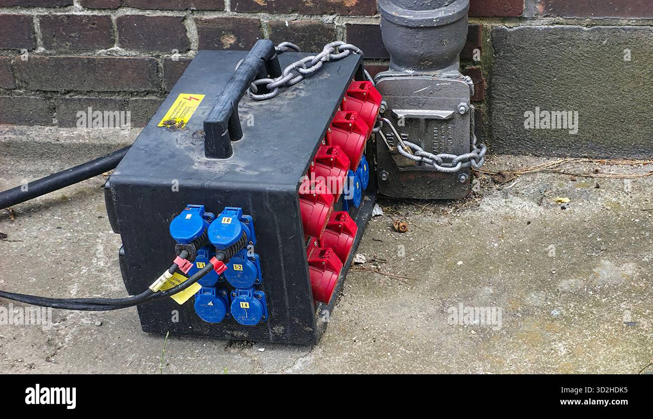 Berlin, Deutschland - 03. Juli 2025: . Elektrischer Stromverteilerkasten mit blauen und roten Steckverbindern am Boden - Smartphone-aufgenommenes Stockfoto