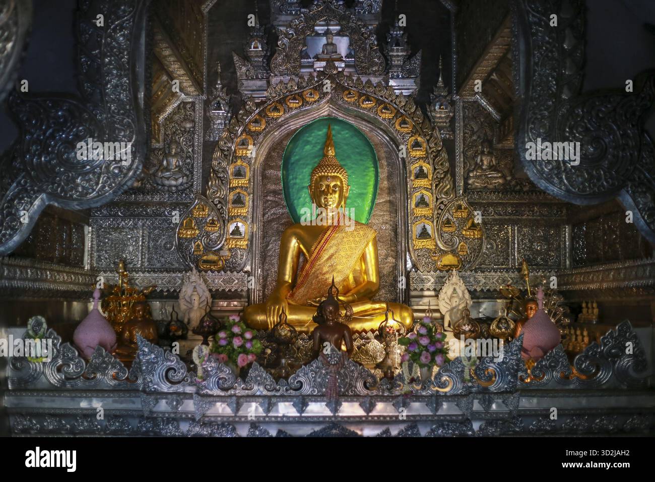 Wunderschöne goldene Buddha-Statue in einem kunstvoll verzierten asiatischen Tempel, die eine friedliche und ruhige Essenz des Buddhismus und religiöse spirituelle Anbetung verkörpert. Stockfoto