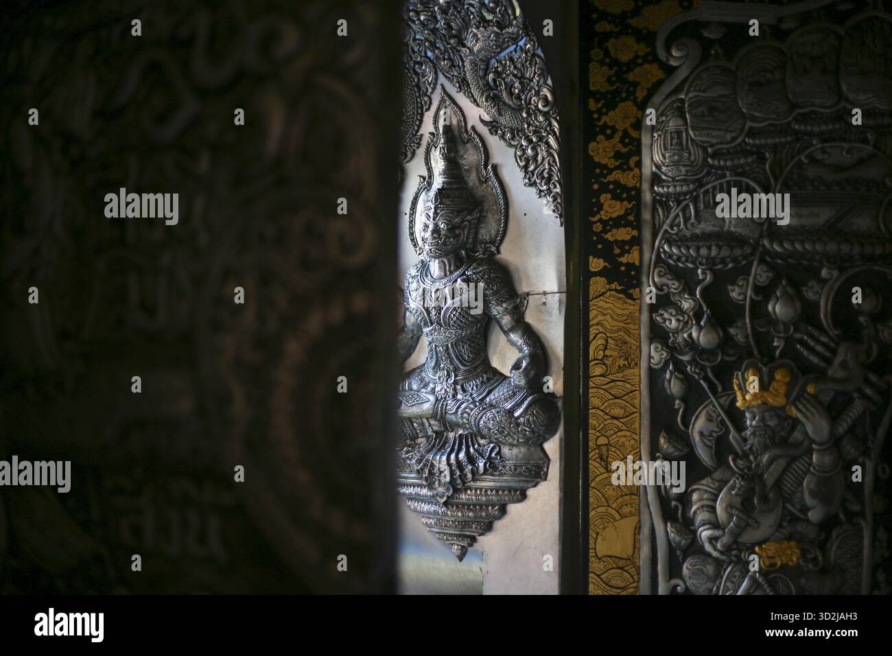 Komplizierte Holzschnitzerei mit heiterer weiblicher Gottheit, wunderschöne asiatische Skulptur. Das detailreiche Kunstwerk zeigt eine anmutige meditative Pose, die ausstrahlt Stockfoto