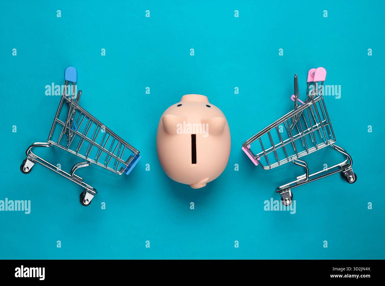 Schweinebank und zwei Mini-Supermarkt-Trolley auf blauem Hintergrund. Minimalistische Studioaufnahme. Draufsicht. Flache Lagen. Stockfoto