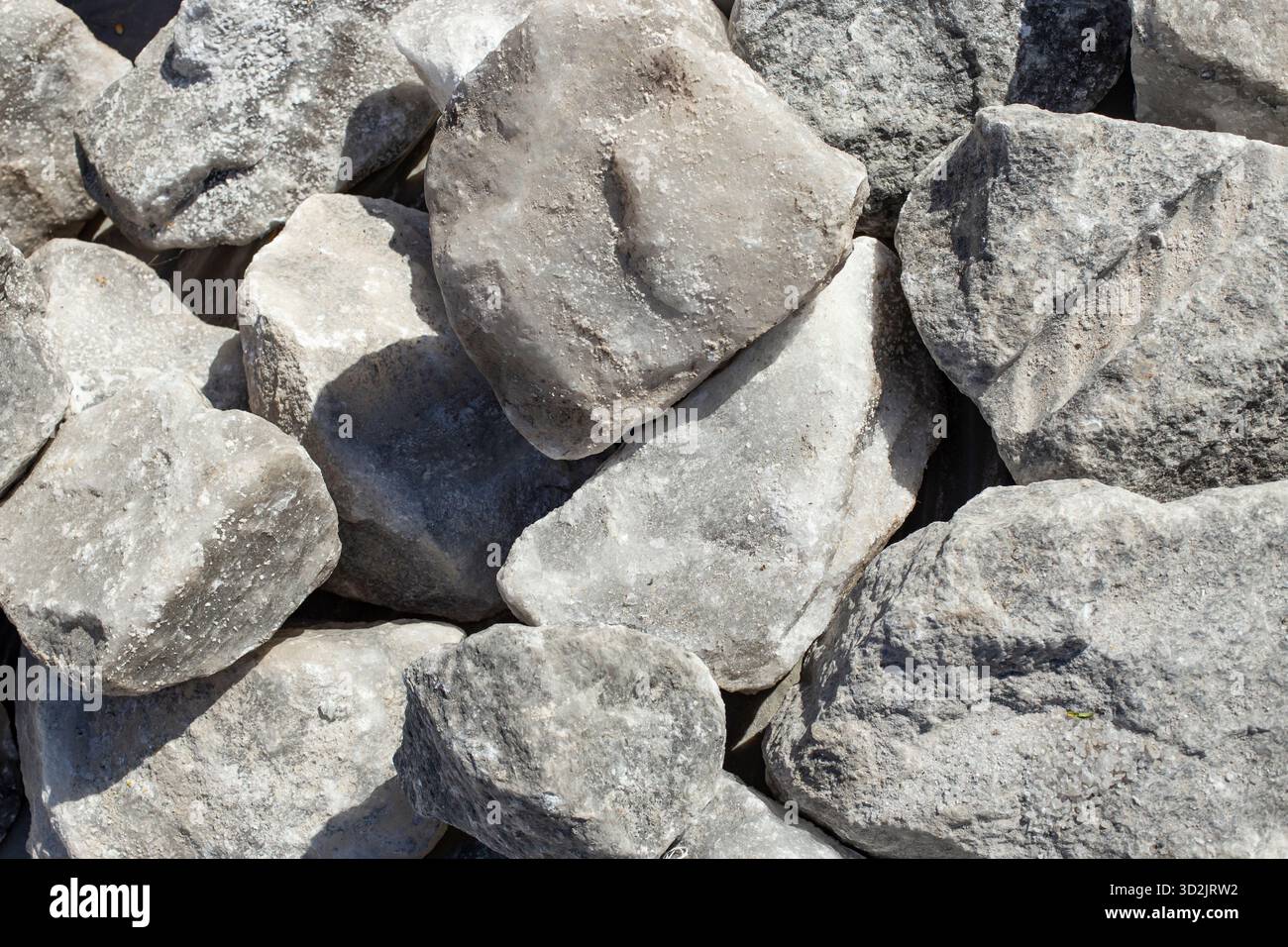 Große rohe Salzblöcke, die sich im Sonnenlicht auftürmen und für Tiere genutzt werden Stockfoto