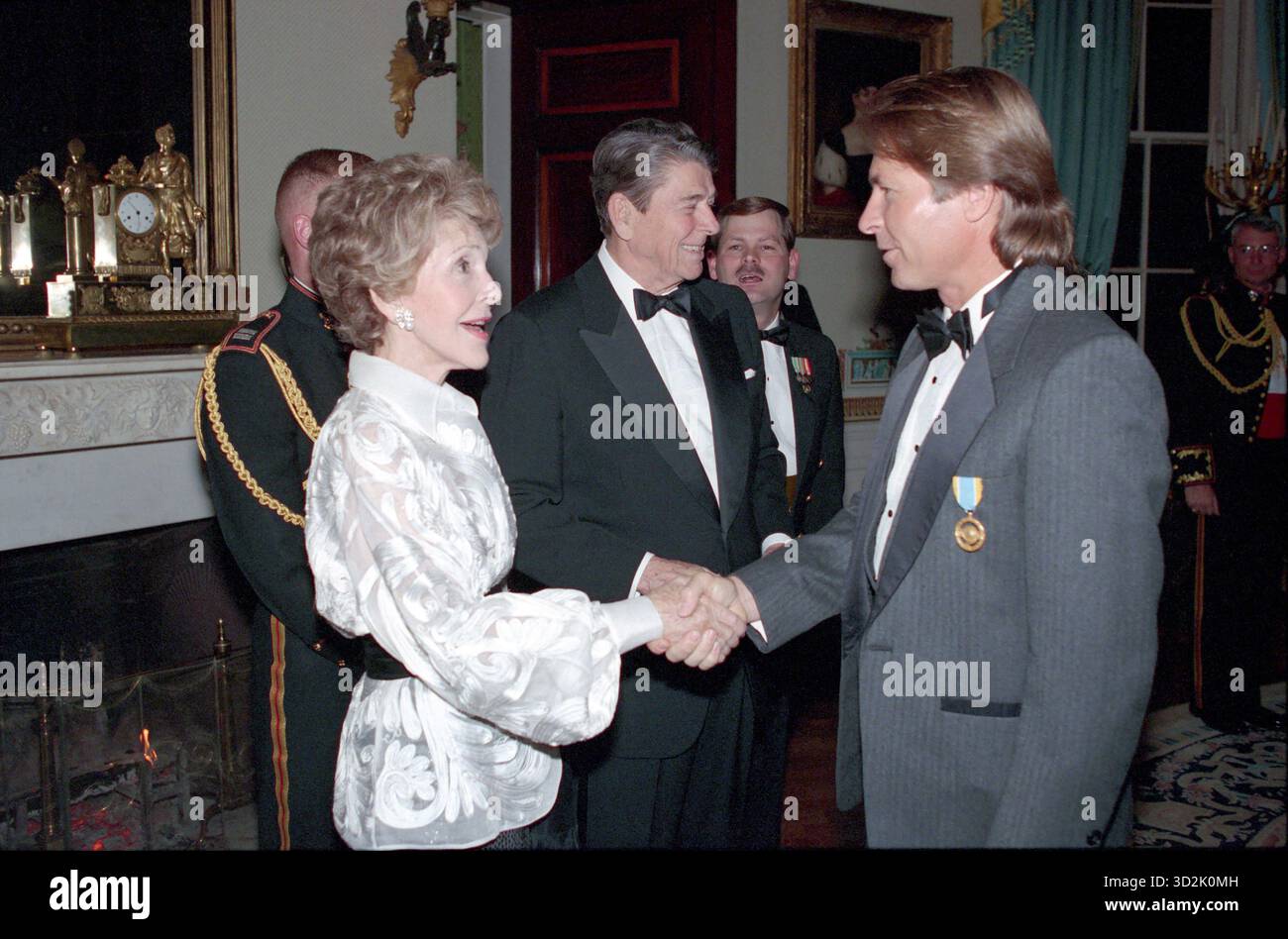 Präsident Reagan und Nancy Reagan begrüßen John Denver in der Empfangsschlange im blauen Zimmer. Foto des Weißen Hauses, 1989 Stockfoto