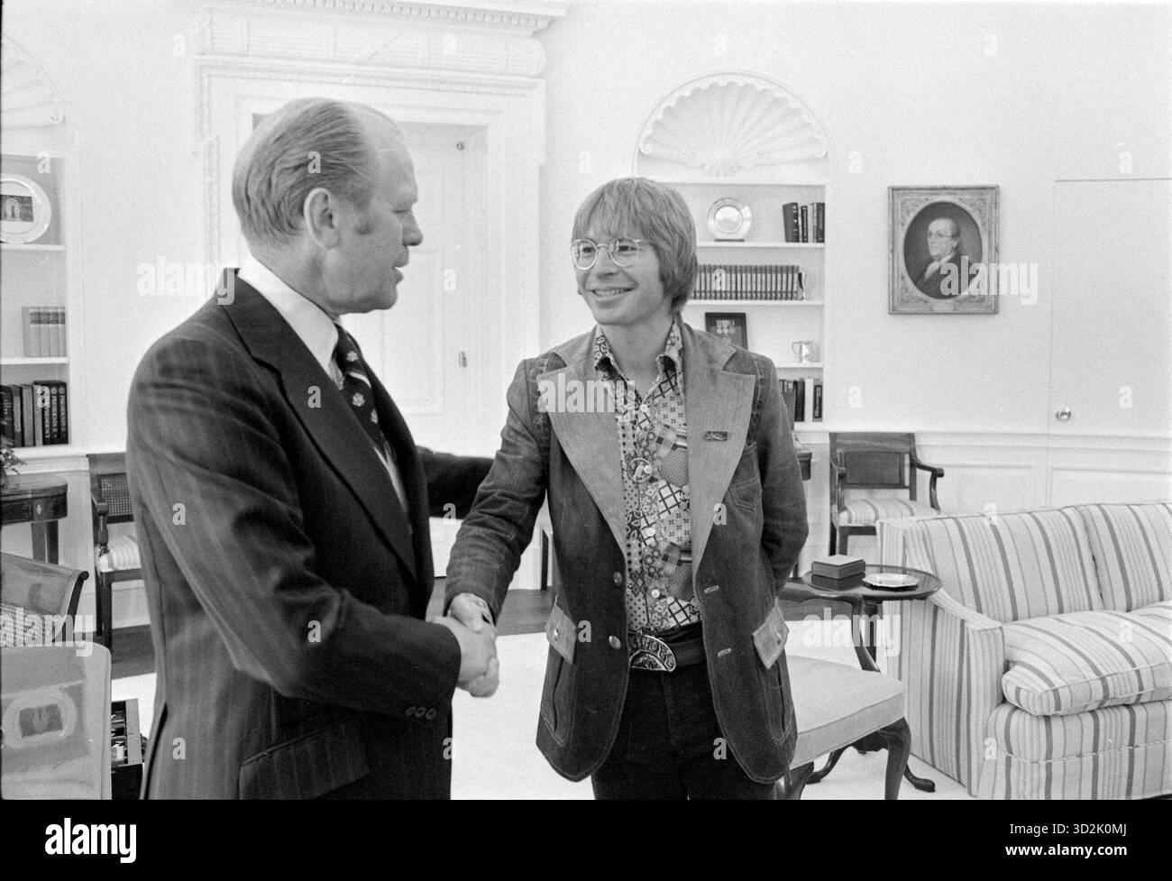 Präsident Gerald R. Ford schüttelt die Hand mit dem Country-Sänger John Denver im Oval Office – Weißen Haus, 14. April 1975 Stockfoto