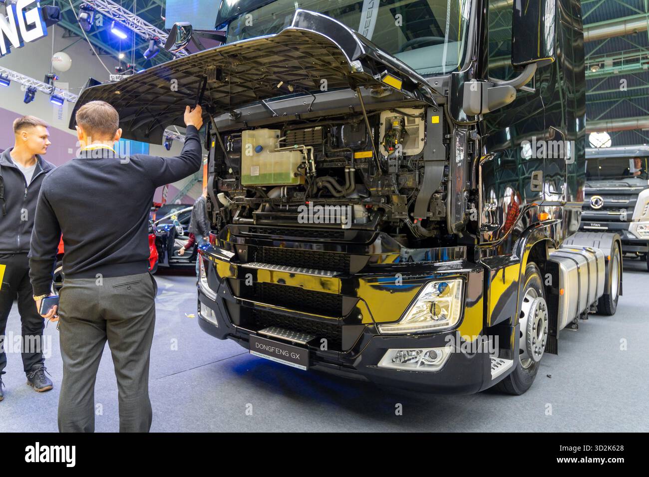 MINSK, WEISSRUSSLAND - 3. JUNI 2025: Ein Dongfeng GX Sattelzugwagen mit offener Kabine wird auf der Motorshow 2025 ausgestellt. Zwei Männer schauen sich den Tru an Stockfoto
