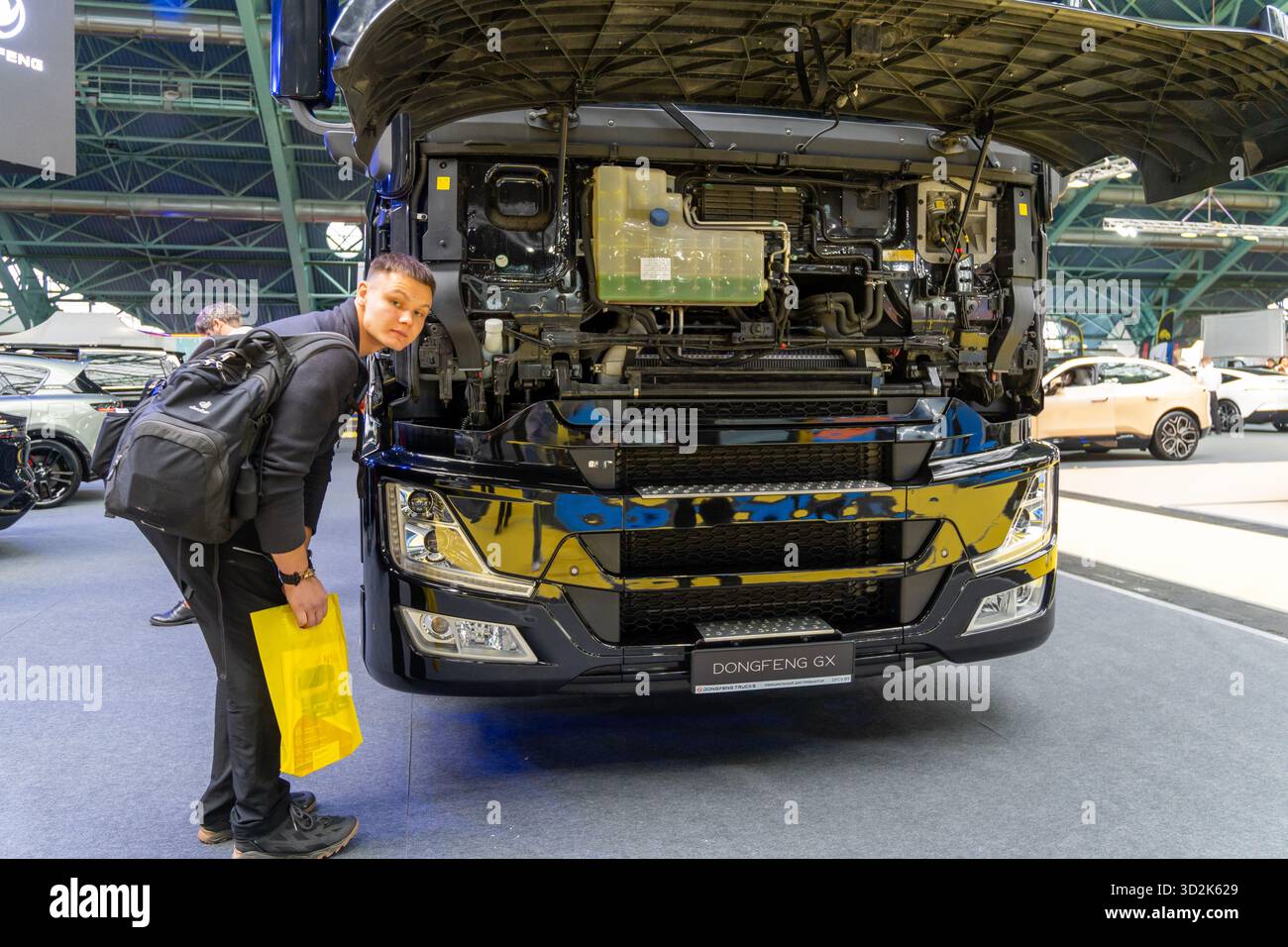 MINSK, WEISSRUSSLAND - 3. JUNI 2025: Ein Dongfeng GX Sattelzugwagen mit offener Kabine wird auf der Motorshow 2025 ausgestellt. Zwei Männer schauen sich den Tru an Stockfoto