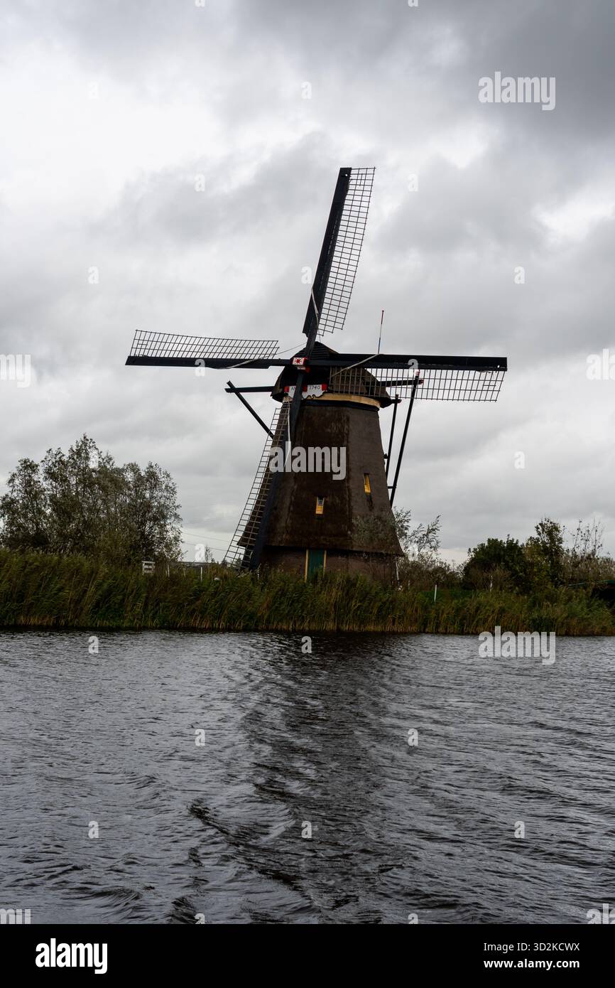 Historische Windmühlen entlang der Wasserstraße im Dorf Kinderdijk, das zum UNESCO-Weltkulturerbe in den Niederlanden gehört. Stockfoto