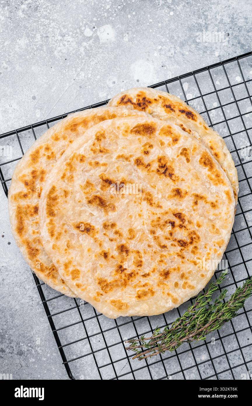 Hausgemachte Kerala-Weizen-Paratha, geschichtete Parotta. Grauer Hintergrund. Draufsicht. Stockfoto