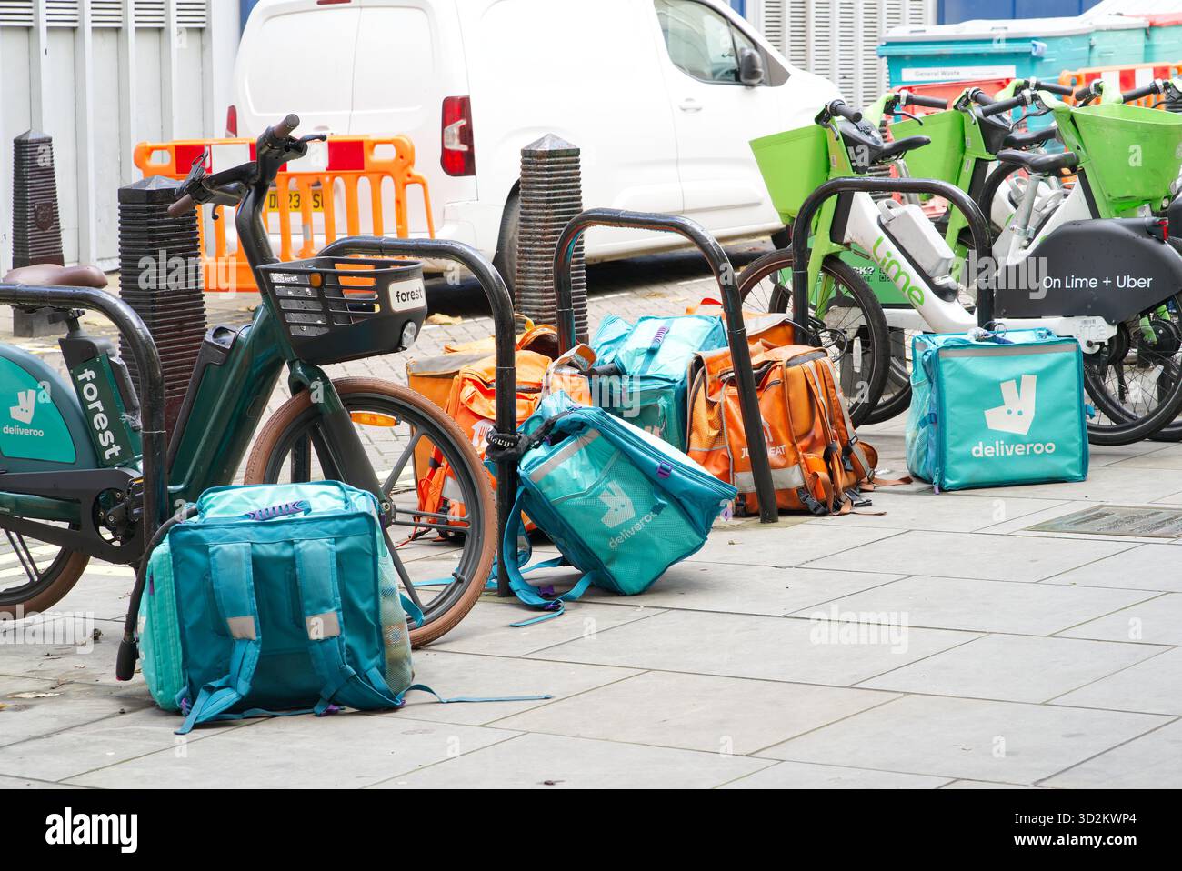 Großer Haufen Deliveroo und essen Sie einfach Lebensmittel-Lieferbeutel, die am Straßenrand abgeladen wurden. London - 2. November 2025 Stockfoto