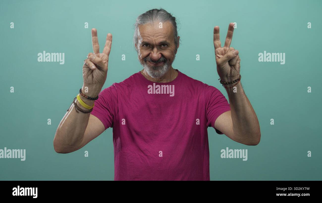 Heiliger Mann mittleren Alters mit langen Haaren, der mit beiden Händen Luftzitierungen in einem blaugrünen Studio zeigt; verspielte Skepsis. Stockfoto