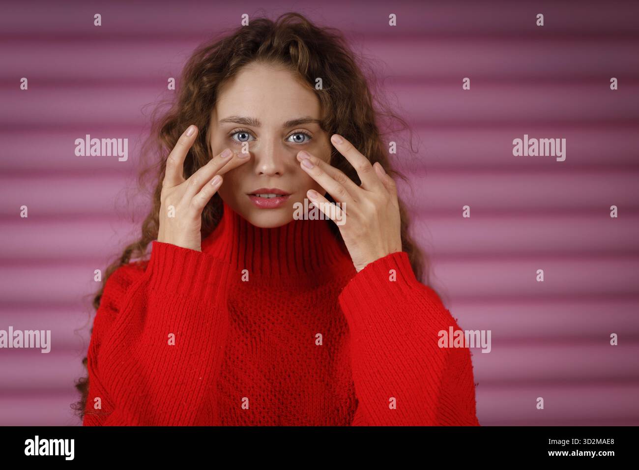 Junge rothaarige Frau, die das Gesicht mit den Fingern berührt, indem sie Gesichts-Yoga-Gesichtsgymnastik-Selbstmassage und Facebuilding-Übung macht Stockfoto