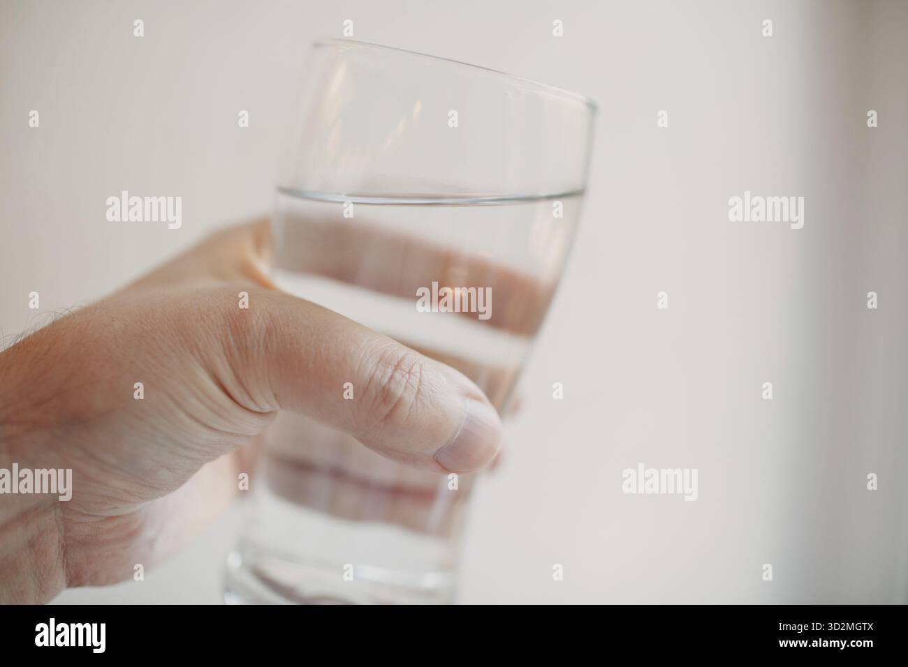 Transparentes Glas mit Wasser in Menschenhand Stockfoto