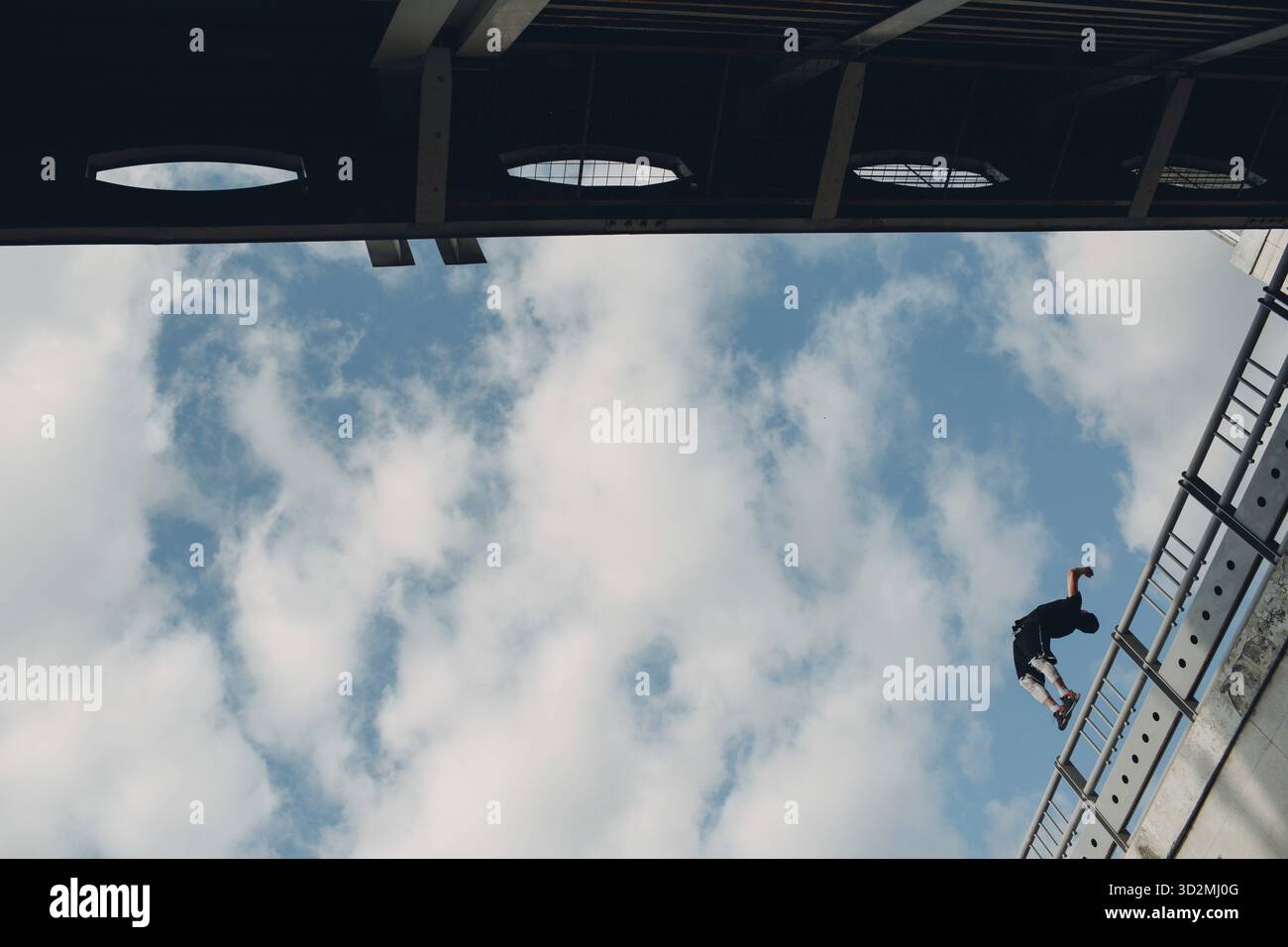 Junger sportlicher Kerl, der Parkour an der Stadtstraße macht Stockfoto