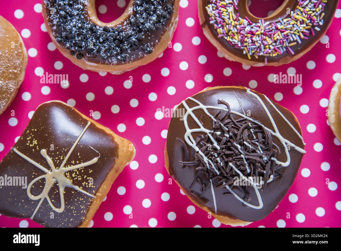 Handwerkliche Donuts auf rosafarbenem Hintergrund von oben Stockfoto