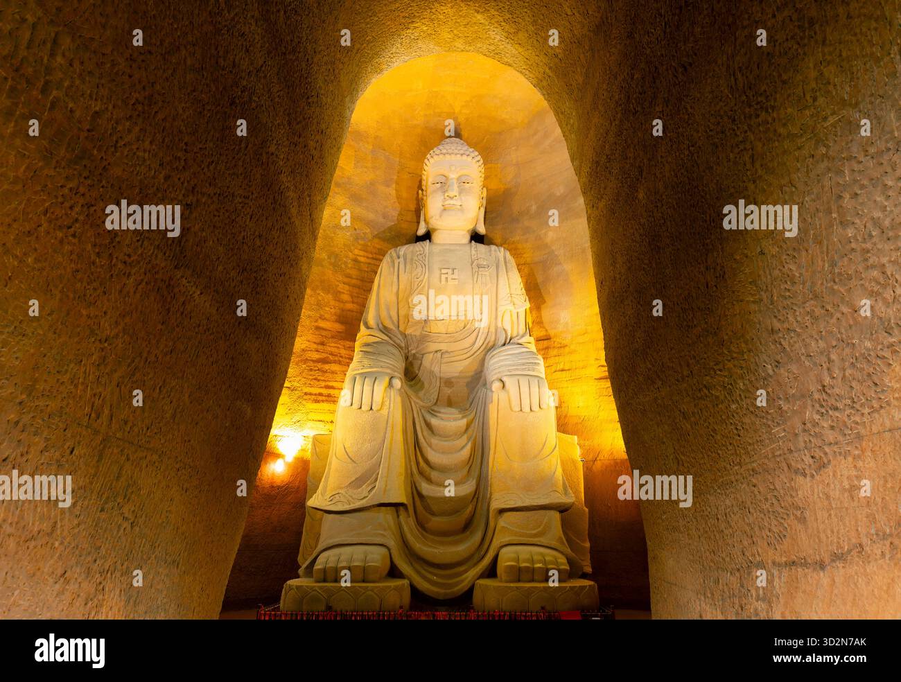 Vertikale Aufnahme einer riesigen Buddha-Statue in einer Höhle in der chinesischen Provinz Sichuan. Stockfoto