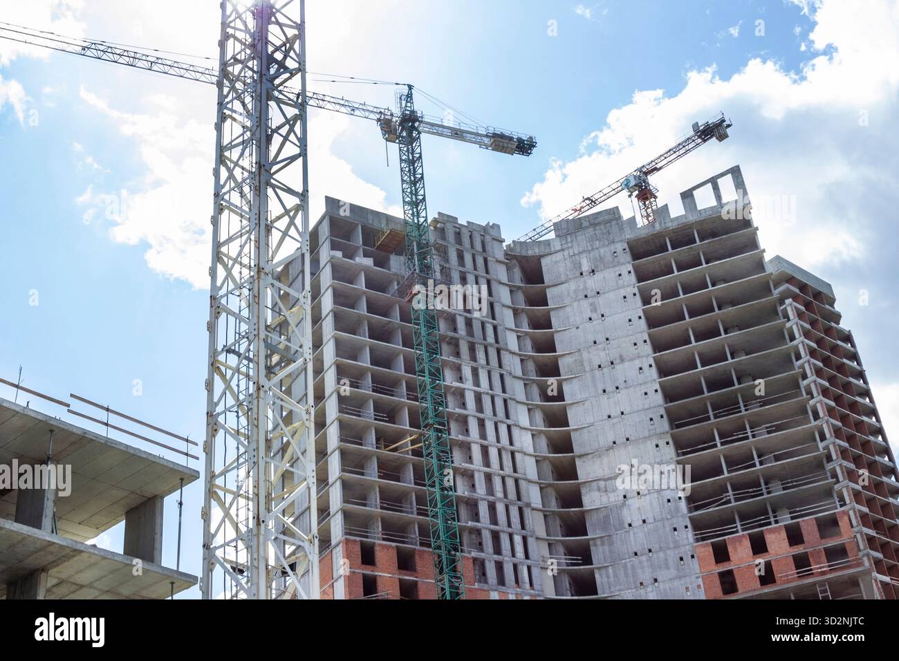 Hochhausbau. Baukran. Unfertiges Haus mit tragenden Wänden und ohne Verkleidung. Stockfoto
